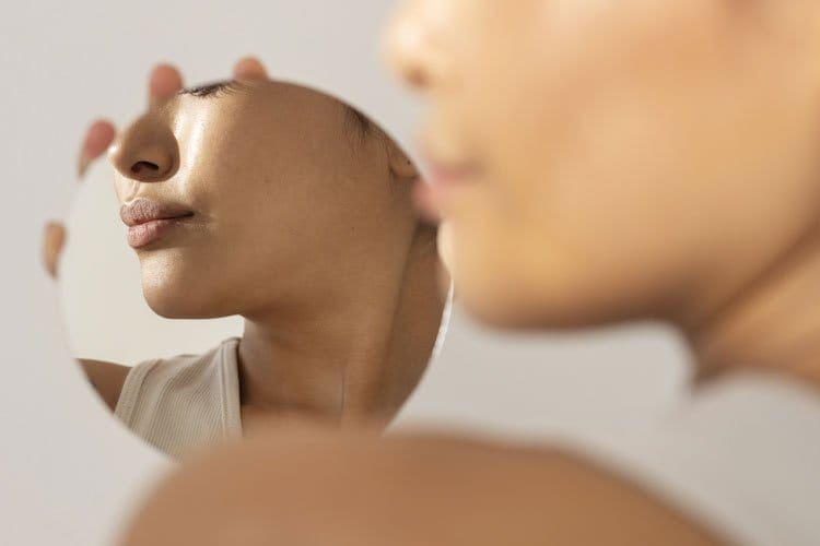 Spiegelblild einer Frau mit hals und Lippen Botox