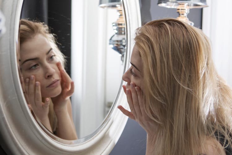 Frau erkennt sich im Spiegel